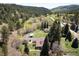 Aerial view showcasing a home and garage nestled in a lush, tree-filled environment, offering privacy and beauty at 10049 S Turkey Creek Rd, Morrison, CO 80465