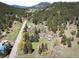 Scenic aerial view of a community nestled in a valley surrounded by lush forested mountains at 10049 S Turkey Creek Rd, Morrison, CO 80465