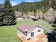 Overhead shot of a house with a deck, surrounded by lush greenery and trees, creating a serene setting at 10049 S Turkey Creek Rd, Morrison, CO 80465