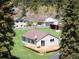 Charming home featuring a wooden deck, neutral siding, and a shingled roof, surrounded by lush greenery at 10049 S Turkey Creek Rd, Morrison, CO 80465