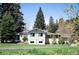 Exterior of a charming single-story home with a well-maintained lawn and mature trees at 10049 S Turkey Creek Rd, Morrison, CO 80465