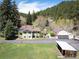 Exterior view of a house with an attached garage, surrounded by a well-kept lawn and mature trees at 10049 S Turkey Creek Rd, Morrison, CO 80465