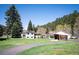 A well-maintained home features a lush green lawn and mature trees, enhancing its curb appeal in a serene setting at 10049 S Turkey Creek Rd, Morrison, CO 80465