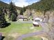Exterior view of a house with an attached garage, surrounded by a well-kept lawn and mature trees at 10049 S Turkey Creek Rd, Morrison, CO 80465