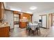 Traditional kitchen with wood cabinets, white appliances, and breakfast nook that opens to living room with views at 10049 S Turkey Creek Rd, Morrison, CO 80465