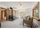 Bright living room with a stone fireplace, large windows, and comfortable seating at 10049 S Turkey Creek Rd, Morrison, CO 80465