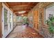 Cozy sunroom with tile floor, wood beam ceiling, stone accent wall, and sliding glass doors at 10049 S Turkey Creek Rd, Morrison, CO 80465
