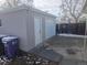 View of detached garage with new door, side door, and concrete driveway at 4720 Thompson Ct, Denver, CO 80216