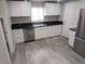 Modern kitchen with stainless steel appliances, white cabinetry, and black countertops at 4720 Thompson Ct, Denver, CO 80216