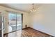 Bright dining area features wood floors, a modern chandelier, and a glass slider to the deck at 17692 E Brown Cir, Aurora, CO 80013
