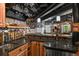 View of the basement bar area, including beer taps, custom backsplash, cabinetry, sink and multiple glasses hanging above at 7243 S Kellerman Way, Aurora, CO 80016