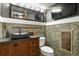 Stylish powder room with a unique stone vessel sink, designer tile, and dark wood cabinetry, as well as a tv at 7243 S Kellerman Way, Aurora, CO 80016