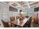 Inviting dining room featuring a wood table, coffered ceilings, and plantation shutters at 7243 S Kellerman Way, Aurora, CO 80016