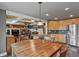 Open-concept kitchen with wood cabinets, stainless steel appliances, and connected living space at 7243 S Kellerman Way, Aurora, CO 80016