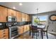Well-equipped kitchen featuring stainless steel appliances and a dining area with backyard view at 7243 S Kellerman Way, Aurora, CO 80016