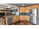 Open-concept kitchen with wood cabinets, stainless steel appliances, and granite countertops at 7243 S Kellerman Way, Aurora, CO 80016