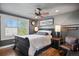Comfortable main bedroom with wood floors, large window, ceiling fan, and accent wall at 7243 S Kellerman Way, Aurora, CO 80016