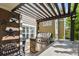 Outdoor kitchen under pergola with a grill, counter space, storage, and star decorations on the wall at 7243 S Kellerman Way, Aurora, CO 80016
