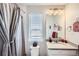 Inviting bathroom featuring soft lighting, a shower with a curtain, and a vanity, creating a relaxing ambiance at 5676 Emporia St, Denver, CO 80238