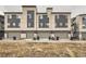 Exterior of multi-Gathering townhomes with gray garages and shared driveways at 5676 Emporia St, Denver, CO 80238