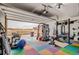 Bright garage features a home gym with vibrant floor mats and ample workout equipment at 5676 Emporia St, Denver, CO 80238