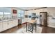 Bright kitchen featuring white cabinetry, stainless steel appliances, and a functional island with seating at 5676 Emporia St, Denver, CO 80238