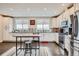 Bright kitchen with white cabinets, stainless steel appliances, and island seating overlooking the outdoor view at 5676 Emporia St, Denver, CO 80238