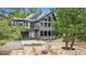 Spacious backyard with a stone patio, fire pit, seating, and lush trees surrounding the property at 7317 Fremont Pl, Larkspur, CO 80118