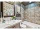 Well-lit bathroom featuring gray walls, tiled shower, and white marble sink at 7317 Fremont Pl, Larkspur, CO 80118