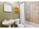 Bathroom with a sink, toilet, tub, shower curtain and yellow shelves at 7317 Fremont Pl, Larkspur, CO 80118