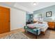 Cozy bedroom with blue accent wall, study desk, and a comfortable bench at 7317 Fremont Pl, Larkspur, CO 80118