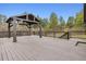 Large deck featuring an outdoor pergola, surrounded by trees at 7317 Fremont Pl, Larkspur, CO 80118