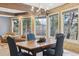 Cozy dining room with wood paneling, a chandelier, and large windows showcasing the trees outside at 7317 Fremont Pl, Larkspur, CO 80118