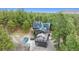 Aerial view of home showing solar panels, outdoor deck, and hot tub among mature trees at 7317 Fremont Pl, Larkspur, CO 80118
