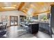 A spacious kitchen features gray cabinets, a center island with bar seating, and a wood plank ceiling with skylights at 7317 Fremont Pl, Larkspur, CO 80118