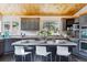 Modern kitchen with gray cabinets, a center island with bar seating, and windows offering scenic outdoor views at 7317 Fremont Pl, Larkspur, CO 80118