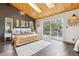 Bright main bedroom with wood plank ceiling, skylight, large windows, and access to a private balcony at 7317 Fremont Pl, Larkspur, CO 80118
