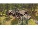 Aerial view showing the house nestled in a wooded setting, along with a deck, outdoor room, and natural surroundings at 3251 Interlocken Dr, Evergreen, CO 80439