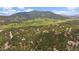 Stunning aerial view of a mountain community with homes nestled in the landscape against the backdrop of the mountains at 3251 Interlocken Dr, Evergreen, CO 80439