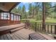 Inviting wooden back deck with wooded views offering ample seating and access to the home's amenities at 3251 Interlocken Dr, Evergreen, CO 80439