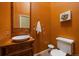 Stylish half bathroom featuring orange walls, unique vanity and fixtures at 3251 Interlocken Dr, Evergreen, CO 80439