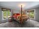 Bedroom with a four-poster bed, views of the outdoors, and neutral walls at 3251 Interlocken Dr, Evergreen, CO 80439