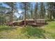 Stunning home exterior featuring natural wood siding, a deck, and lush greenery at 3251 Interlocken Dr, Evergreen, CO 80439