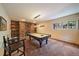 Game room featuring a pool table, stone fireplace, built-in shelves, and a SALOON sign at 3251 Interlocken Dr, Evergreen, CO 80439