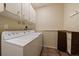 Laundry room featuring white washer and dryer, overhead cabinets, and drying rack at 3251 Interlocken Dr, Evergreen, CO 80439