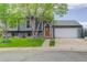 Charming gray home featuring stone accents, manicured lawn, and an attached two-car garage at 5861 S Orleans Way, Centennial, CO 80015
