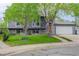 Charming gray two-story home boasting beautiful green lawn, an attached two-car garage, and mature shade trees at 5861 S Orleans Way, Centennial, CO 80015