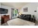 Bright living room with large window, modern decor, and a comfortable black leather sofa at 5861 S Orleans Way, Centennial, CO 80015