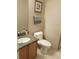 Half bathroom with granite countertop, wood cabinet, and decorative towel bar at 5256 E 129Th Pl, Thornton, CO 80241