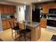 Kitchen featuring wood cabinets, an island with granite countertop, and stainless steel appliances at 5256 E 129Th Pl, Thornton, CO 80241